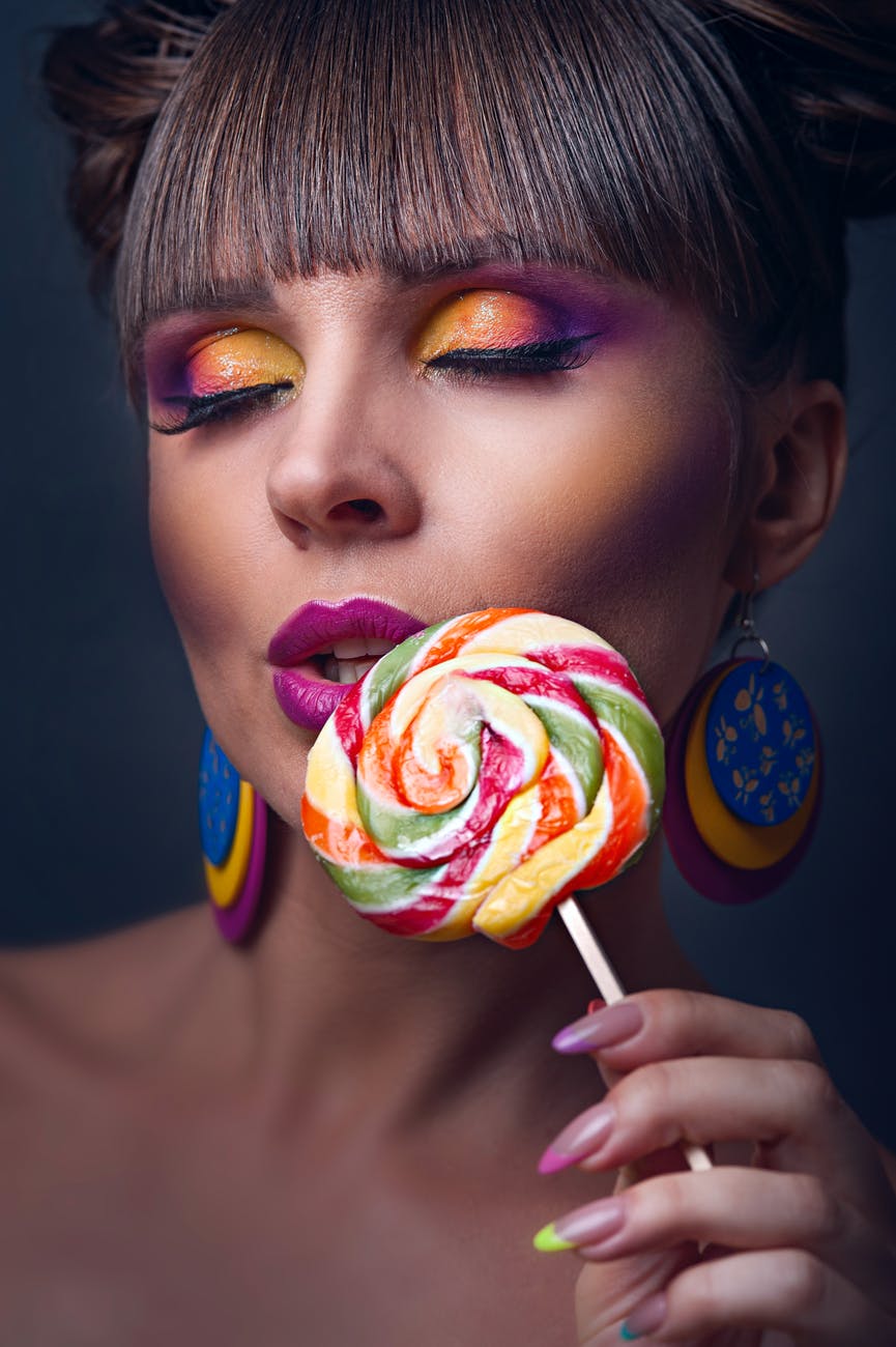 close up photo of woman holding lollipop